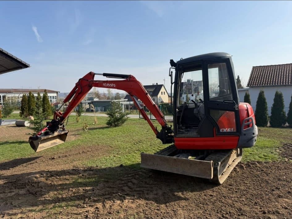 Roter Kettenbagger beim Planieren einer Grundstücksfläche